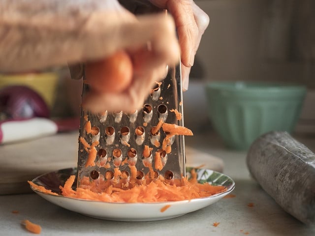 Für den Karottensalat musst du das Wurzelgemüse zunächst raspeln.