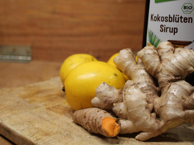 Zutaten für einen veganen Ingwer-Shot: Natürliche Süße durch Sirup, Dicksaft oder Honig, Zitronen und natürlich Ingwer.