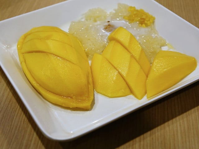 Klebreis wird traditionell mit Kokosmilch und geschnittener Mango serviert.