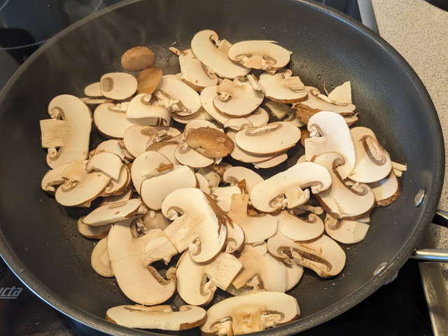Brate die Champignons scharf in einer Pfanne an.