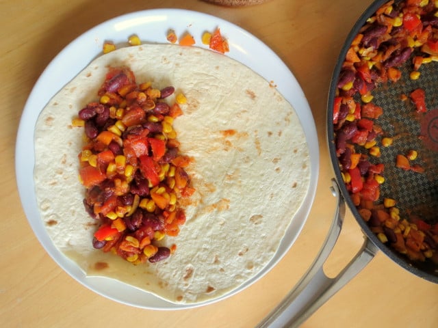 Damit du die Tortillas gut aufrollen kannst, verteile die Füllung nur auf einer Hälfte des Teigfladens und lass die Ränder frei.