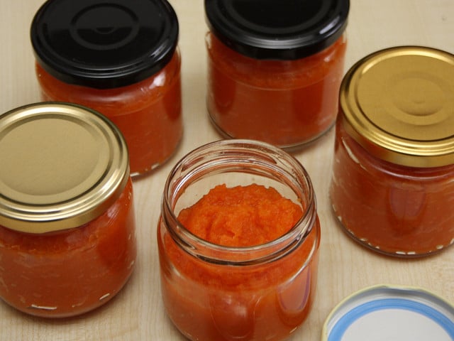 Fülle die Karottenmarmelade in saubere Gläser mit Schraubverschluss.