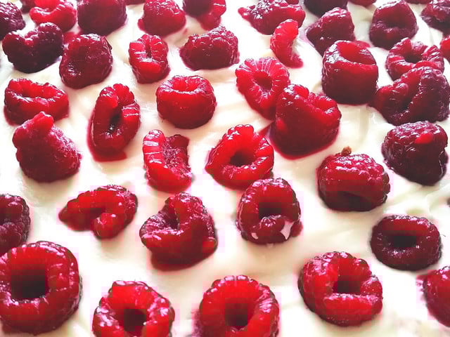 Rezept: Poke Cake mit Himbeer-Nektarinen-Füllung Die Sahneschicht des Poke Cake kannst du mit Himbeeren verzieren.