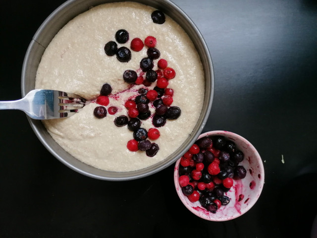 Verteile die Beeren mit einer Gabel im Teig.