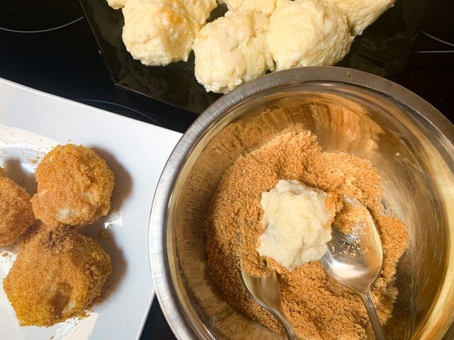 Wälze die gar gekochten Nougatknödel in einer Mischung aus Zucker und Semmelbröseln.