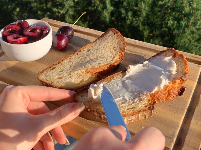 Verteile den Frischkäse auf dem Brot.