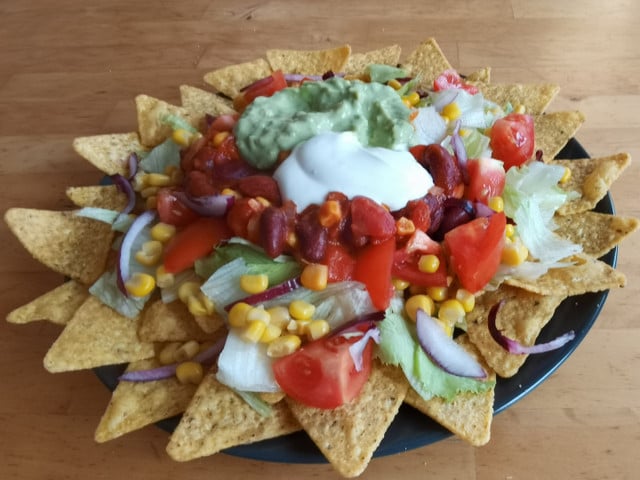 Richte den Taco-Salat auf einem großen Teller an.