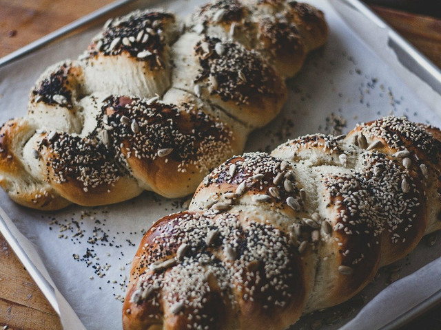 Bestreue das Schabbat-Brot Challah vor dem Backen mit Saaten.