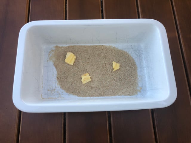 Damit das Gateau di Patate schön knusprig wird, gibst du Semmelbrösel und Butter auf den Boden der Form.