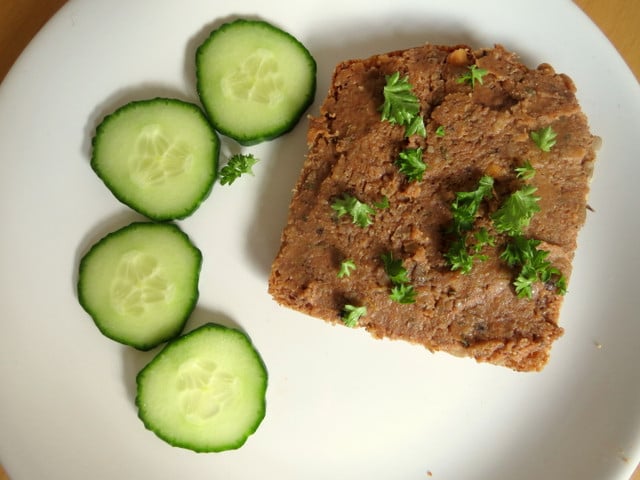 Vegane Leberwurst schmeckt gut auf kräftigem Brot und mit frischen Kräutern garniert.