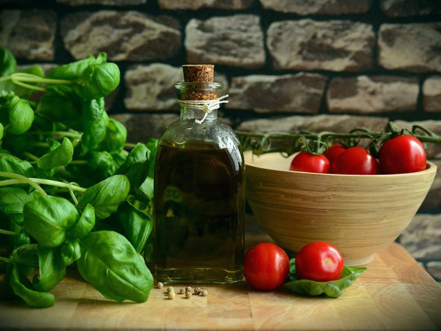 In den italienischen Nudelsalat kommen Basilikum, Tomaten und Olivenöl.