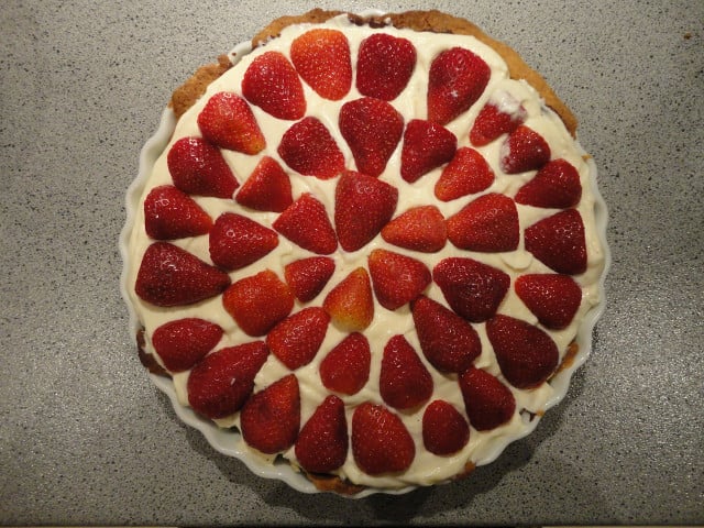 Ein veganer Erdbeerkuchen sieht besonders lecker aus, wenn du die Erdbeeren gleichmäßig platzierst.