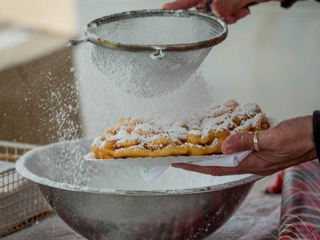 Strauben mit Puderzucker und Preiselbeermarmelade findest du oft auf Dorffesten.