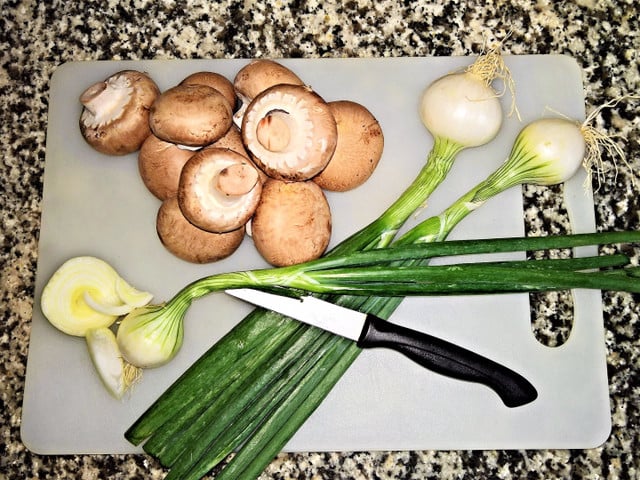 Champignons und Frühlingszwiebeln passen gut in eine asiatische Gemüsepfanne.